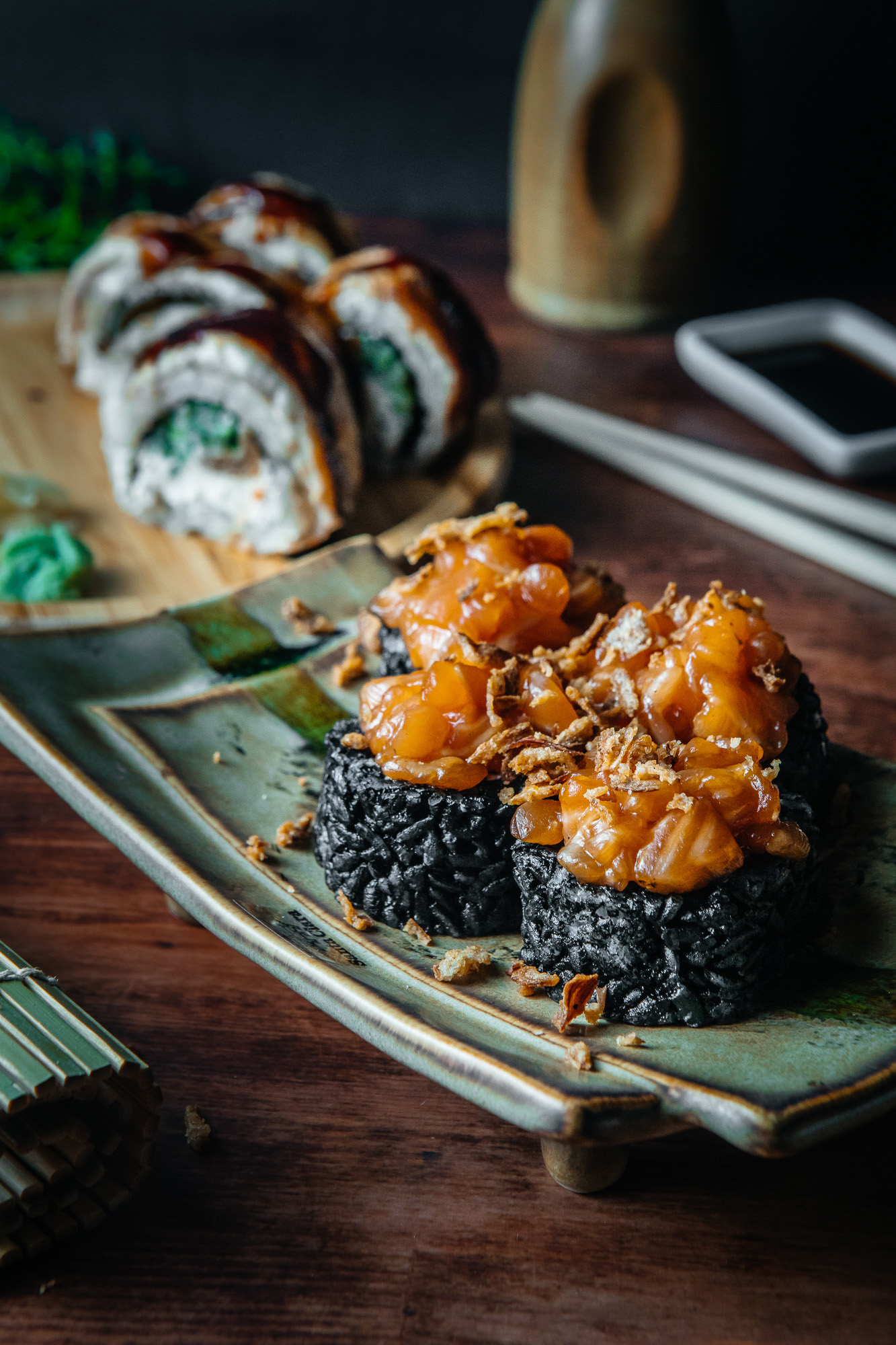 Selección de sushi con diferentes coberturas sobre una bandeja oscura.
