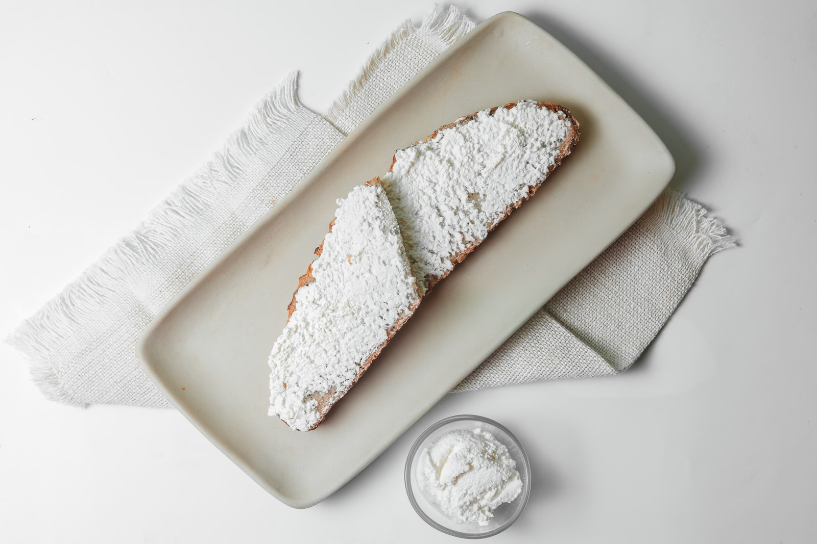 Tostadas con una cobertura blanca sobre una tabla clara.