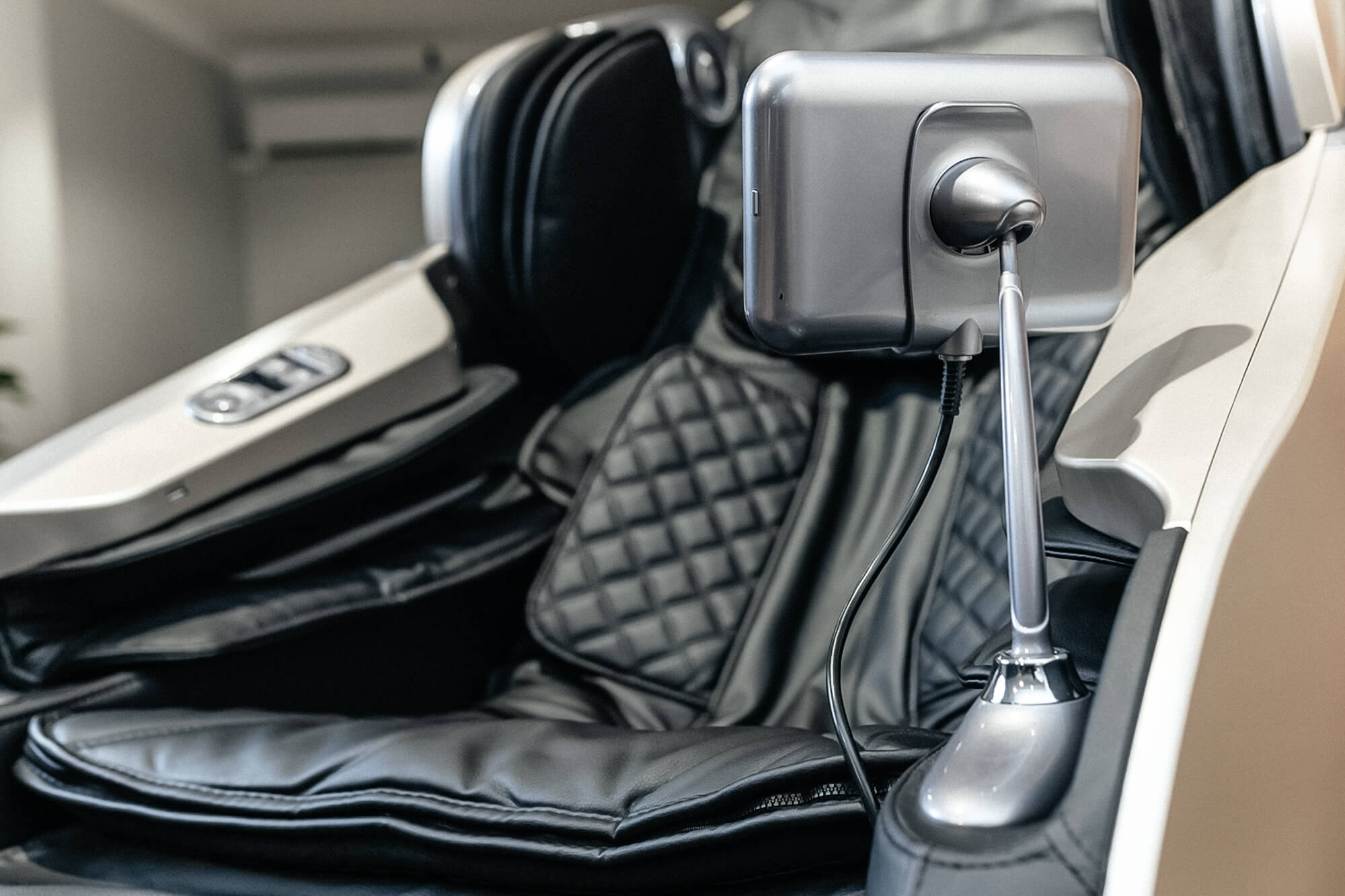 Detalle del asiento, los apoyabrazos y el control de un sillón de masaje.