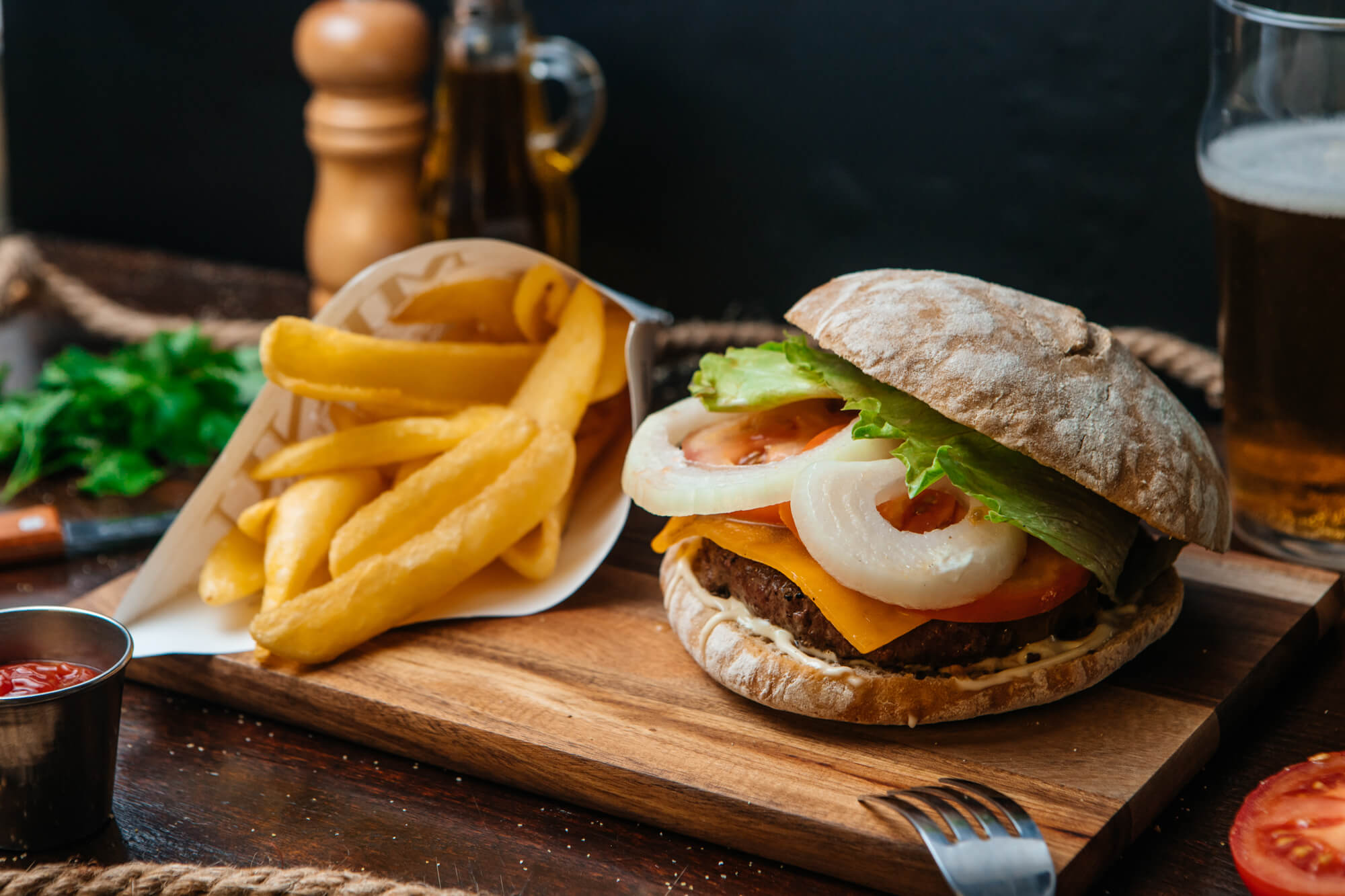 Hamburguesa con huevo, cebolla y lechuga acompañada de patatas fritas.